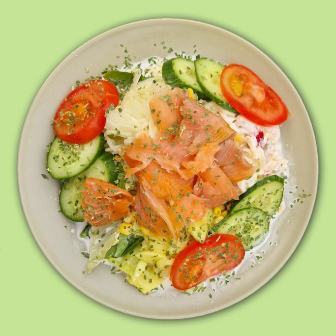 Lachssalat mit Gurken und Tomaten garniert